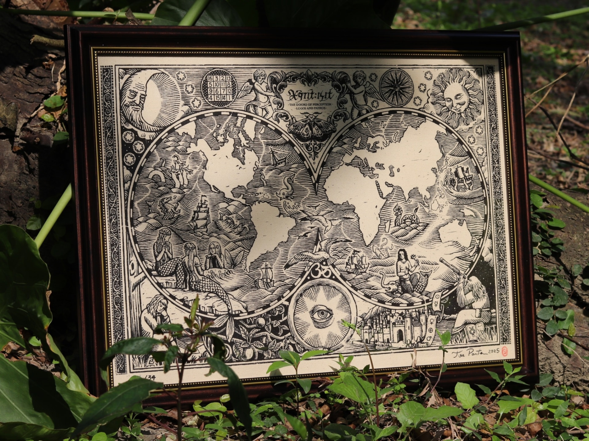 Framed World Map hand-pulled silkscreen print displayed outdoors among green foliage